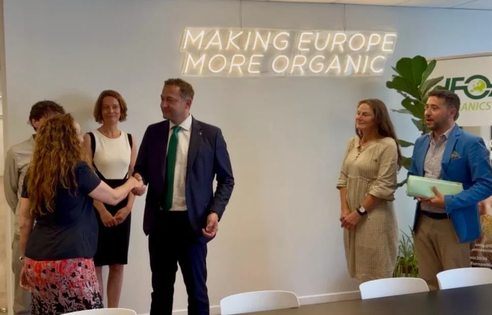 Evelyne Alcázar junto al Comisario Europeo Christophe Hansen